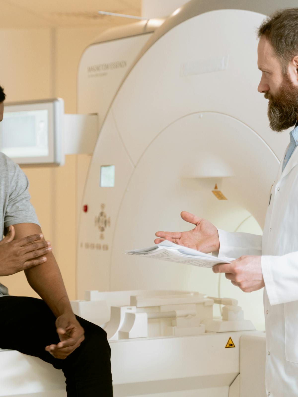 Paciente acompanada por personal sanitario en una prueba de diagnostico por imagen.