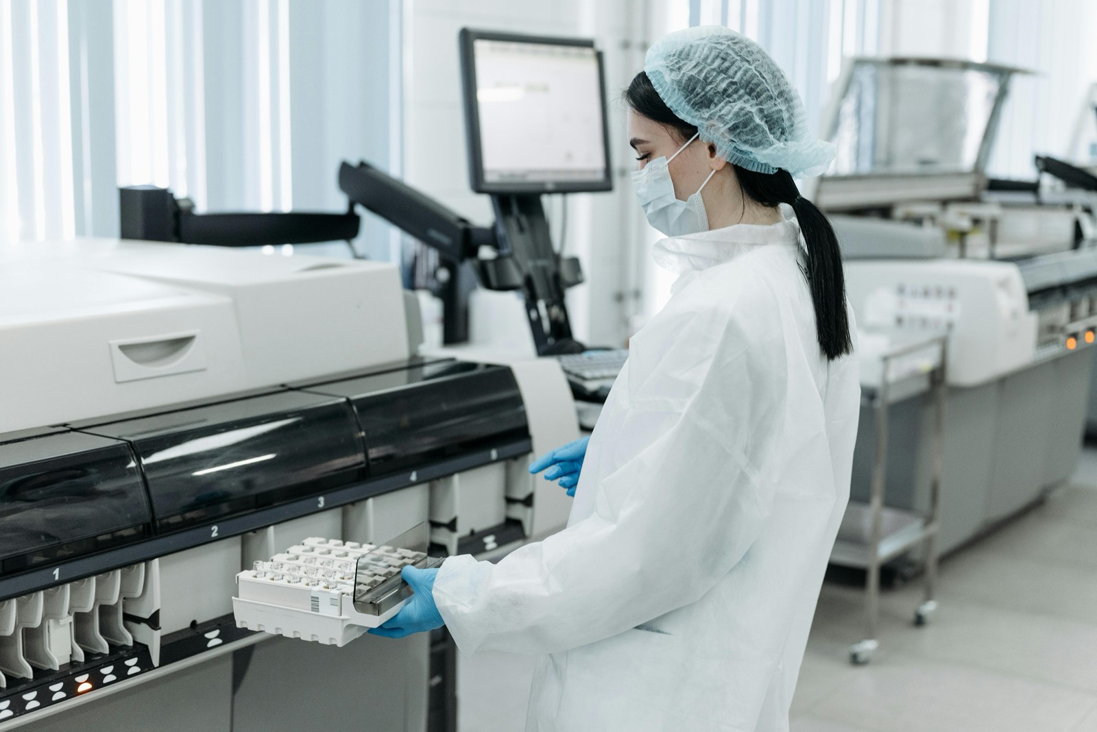 Tecnica de laboratorio trabajando con equipo de analisis clinico.