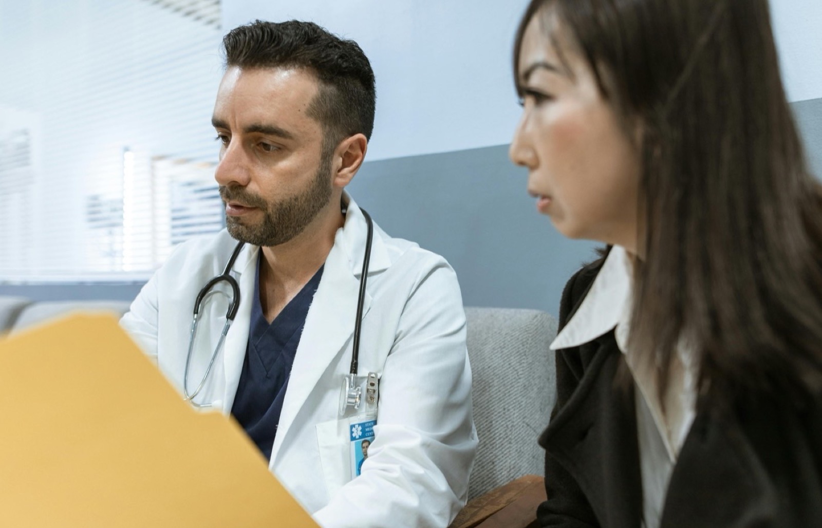 Profesional sanitario revisando un expediente clinico durante una consulta.